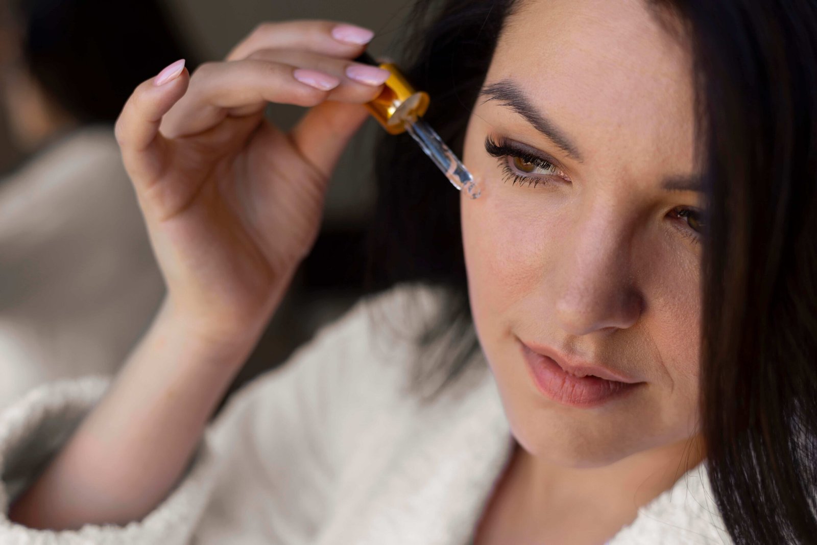 Mujer aplicándose aceite facial con gotero de Ana Estada.